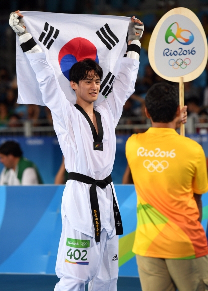 태권도 국가대표 이대훈 선수가 18일 오후(현지시간) 브라질 리우데자네이루 바하 올림픽파크 카리오카 아레나3에서 열린 2016 브라질 리우올림픽 태권도 남자 68kg급 동메달결정전에서 벨기에의 자우드 아찹과의 경기에서 승리하며 동메달을 획득했다. 태극기를 들고 환하게 웃는 이대훈.  리우데자네이루=올림픽사진공동취재단