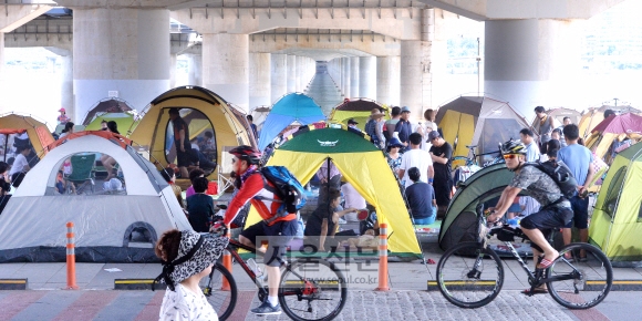폭염이 한달 가까이 계속되고 있는 가운데 지난 21일 서울 영등포구 여의도 마포대교 남단 다리밑에서 시민들이 텐트를 치고 물놀이를 즐기며 더위를 식히고 있다. 이종원 선임기자 jongwon@seoul.co.kr