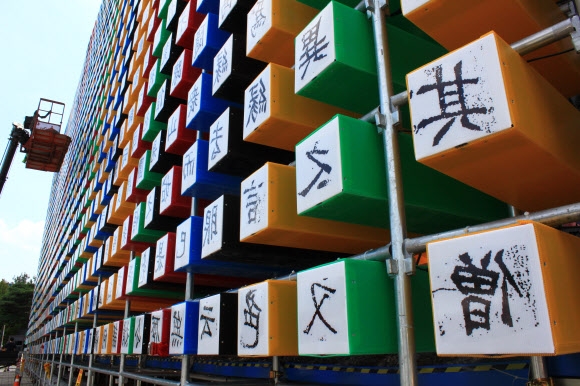 다음달 1일 직지코리아 국제페스티벌이 열리는 충북 청주 예술의전당 광장에서 21일 세계에서 가장 오래된 금속활자본인 직지심체요절(直指心體要節)을 상징하는 ‘직지 월’(WALL) 설치가 한창이다. 직지 월은 격자형 박스 8000여개의 앞뒤에 직지 하권에 실린 1만 6000여개의 한자를 새겨 높이 11.7m, 길이 87m 규모로 만든다. 행사장 밖에서는 글자가 거꾸로 돼 있지만 내부로 들어가면 인쇄된 글자를 볼 수 있다. 청주 연합뉴스