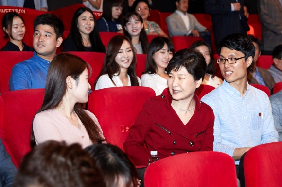 박근혜 대통령이 지난 20일 서울 용산의 한 극장에서 영화 ‘인천상륙작전’을 관람하기 전 옆자리에 앉은 청와대 행정 인턴들과 대화하고 있다. 청와대 제공