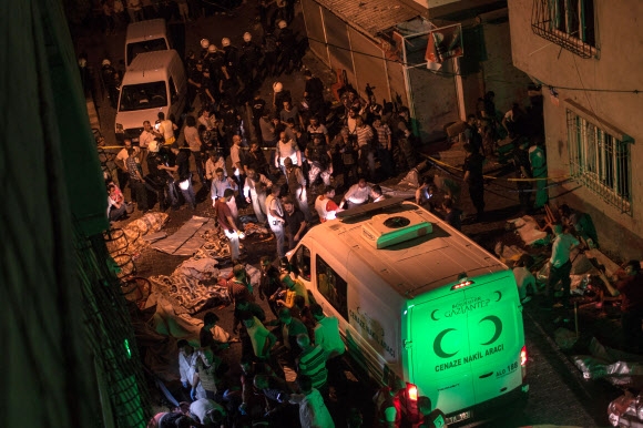 터키 남동부 가지안테프 도심의 한 결혼 축하파티 현장에서 20일(현지시간) 폭탄 테러가 발생한 직후 현장에 급파된 구급대원과 경찰관이 현장을 수습하고 있다. 최소 51명이 숨지고 94명이 부상당한 것으로 알려진 가운데 터키 정부는 이슬람 수니파 극단주의 무장세력인 이슬람국가(IS)의 소행으로 추정된다고 밝혔다. 가지안테프 AFP 연합뉴스