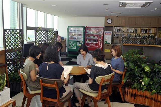서울 노원구 독서동아리에 속한 직원들이 구청 휴식 공간에 앉아 책을 읽으며 의견을 나누고 있다.