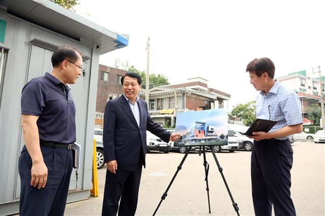 이성(가운데) 구로구청장이 22일 서울 구로구 가리봉동 내 가족통합지원센터 건립 예정부지에서 센터 조형도를 손으로 가리키며 관계자들과 대화를 나누고 있다. 구로구 제공