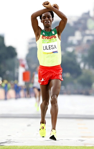 남자 마라톤에서 은메달을 딴 페이사 릴레사(에티오피아)가 22일 결승선을 통과할 때 두팔을 들어 ‘엑스’를 만들어 보이고 있다. 리우데자네이루 EPA 연합뉴스