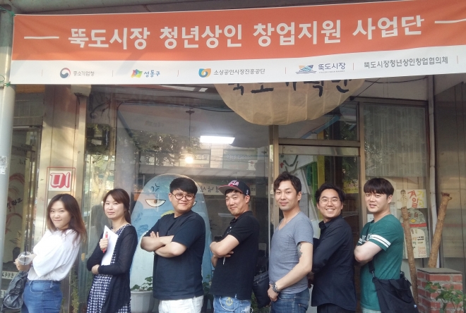 25일 서울 성동구 뚝도시장에 둥지를 틀 청년상인 7명이 기념사진을 찍고 있다. 이들은 뚝도시장의 활성화를 위해 치킨과 수제맥주 등 먹거리와 아트숍 등을 운영할 예정이다. 성동구 제공