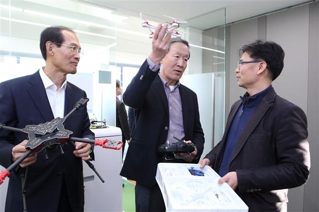 허창수(가운데) GS그룹 회장이 지난 3월 전남 여수 전남창조경제혁신센터를 방문해 입주기업인 마린로보틱스의 서경필(오른쪽) 대표로부터 위성항법장치(GPS) 자율비행 기반 농약 살포 방제용 드론 개발 및 사업 내용에 대한 설명을 듣고 있다. GS그룹 제공