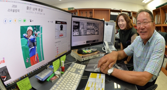 박경래(오른쪽) 대표와 한 직원이 리우올림픽에서 윈엔윈 활을 사용한 북한 강은주 선수 관련 서울신문 인터넷기사를 보며 웃음 짓고 있다.