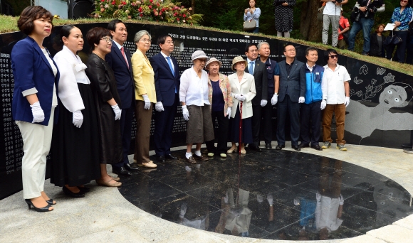 지난 29일 오후 서울 중구 예장동 남산공원 옛 통감관저터에서  열린 일본군 ’위안부’ 기억의 터 제막식에 참석한 김복동, 길원옥 할머니와 박원순 시장, 우상호 더불어민주당 원내대표 등이 조형물 ’대지의 눈’ 앞에서 기념촬영을 하고 있다. 이언탁 기자 utl@seoul.co.kr