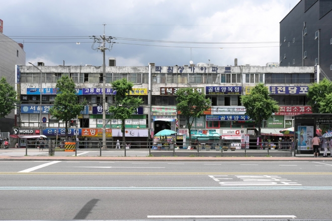 좌원 아파트 전경. 가로 폭이 넓고 전면 도로인 수색로보다 건물이 낮아 매우 납작하게 보인다. 1, 2층은 상가, 3, 4층은 공동 주거다. 건축가 황두진 제공