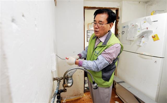유덕열 서울 동대문구청장이 보듬누리 사업에 직접 참여해 노후주택에 페인트를 칠하고 있다. 동대문구 제공
