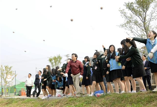 김기동(가운데) 구청장이 지난해 10월 중랑천 체육공원에서 열린 ‘광진 녹색거리한마당’에 참가한 대원여고 학생들과 함께 중랑천 수질 개선을 위해 유용미생물(EM) 흙공을 던지고 있다. 광진구 제공