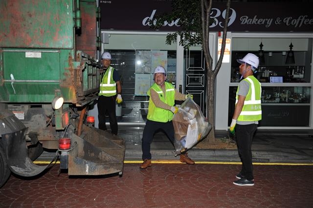 이 시장이 새벽 미화원들과 함께 청소차에 동승해 쓰레기 청소를 하고 있다.