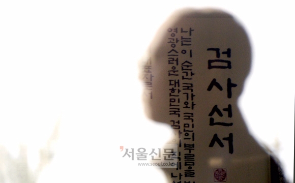 서울 중앙지검에서 한 직원이 검사선서를 지나고 있다.