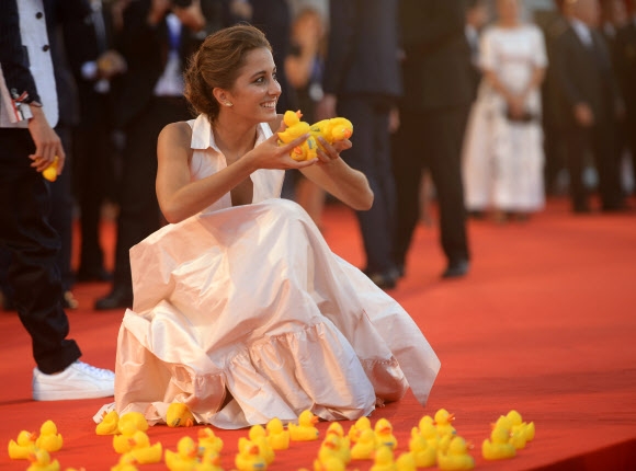 5일(현지시간) 이탈리아 베니스에서 열린 제73회 베니스국제영화제에서 배우 블루 요시미가 영화 ‘피우마(Piuma)’ 프리미어 행사에 참석해 레드카펫 위에 놓인 러버덕들을 들어보이고 있다. AFP 연합뉴스