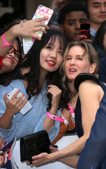 5일(현지시간) 영국 런던에서 열린 영화 ‘브리짓 존스의 베이비(Bridget Jones’s Baby)’ 월드 프리미어 행사에 참석한 배우 르네 젤위거가 팬들과 함께 셀카를 찍고 있다. AP 연합뉴스