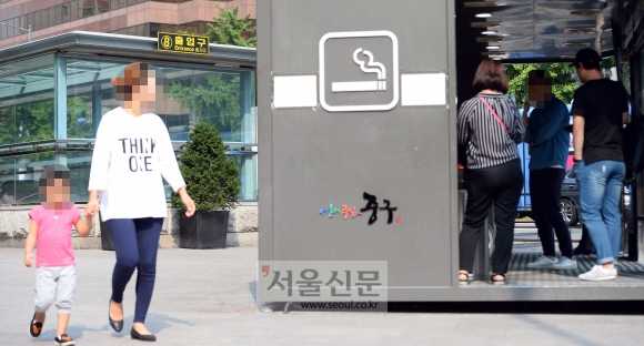 6일 서울 중구 을지로입구역 8번 출구 근처에 설치된 흡연실 옆을 한 시민이 아이와 함께 지나고 있다. 박윤슬 기자 seul@seoul.co.kr
