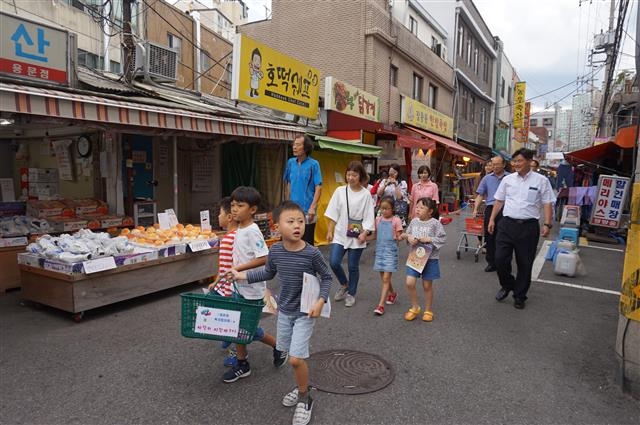 지난달 29일 서울 용산구 용문시장에서 열린 사랑의 장바구니 행사에서 아이들이 장바구니를 들고 시장 안을 돌며 물품을 기부받고 있다. 용산구 제공