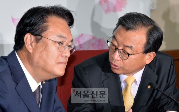 새누리당 이정현(오른쪽) 대표가 8일 서울 여의도 당사에서 열린 최고위원회의에서 정진석 원내대표에게 심각한 표정으로 얘기하고 있다. 이종원 선임기자 jongwon@seoul.co.kr