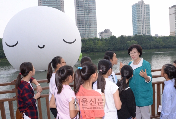 박춘희 서울 송파구청장이 어린이들과 함께 석촌호수에 띄워진 슈퍼문 앞에서 보름달의 의미와 공공미술에 대해 이야기를 나누고 있다. 최해국 선임기자 seaworld@seoul.co.kr