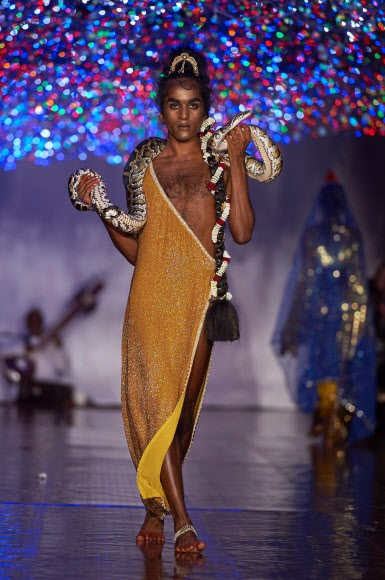 19일(현지시간) 영국 런던에서 열리고 있는 런던 패션위크에서 패션 브랜드 ‘아쉬시(Ashish)’의 2017 봄/여름 컬렉션 의상을 입은 모델이 뱀을 목에 두르고 런웨이를 걷고 있다.<br>AFP 연합뉴스