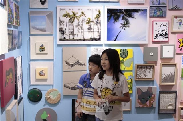 갤러리 토스트에서 젊은 작가들의 미술작품을 감상하는 어린이들.