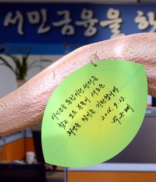 3일 박근혜 대통령이 중구 세종대로에 중앙 서민금융통합지원센터 개소식에 참석해  국민행복나무 행복카드를 작성하고 있다.  안주영 기자 jya@seoul.co.kr