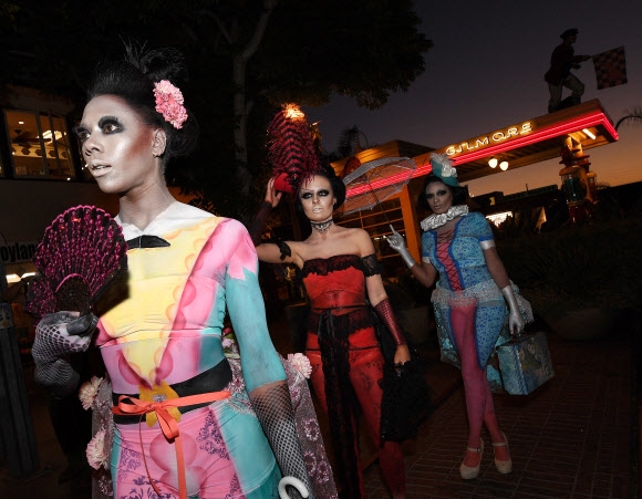 22일(현지시간) 미국 캘리포니아주 로스앤젤레스에서 열린 ‘2016 메트로폴리탄 패션위크(Metropolitan Fashion Week)’ 오프닝에서 핼러윈 테마로 분장한 모델들이 사탕을 붙인 드레스를 입고 퍼레이드를 하고 있다.  AFP 연합뉴스