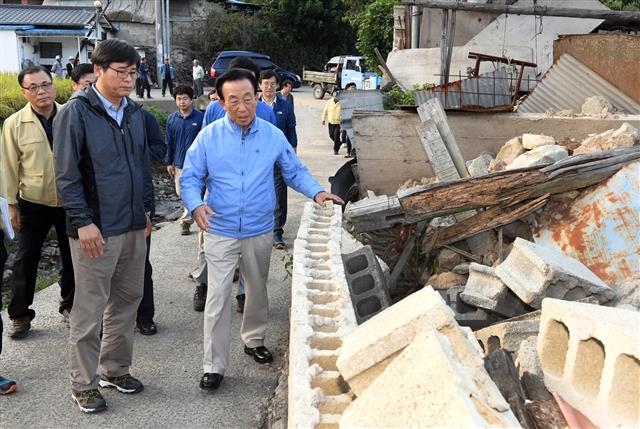 김관용(오른쪽) 경북도지사가 지난 24일 지진 피해 마을인 경주 내남면 비지리를 찾아 현장을 둘러보고 있다. 경북도 제공