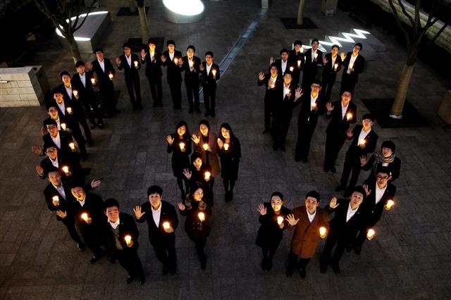 지난해 GS그룹의 칼텍스 신입 사원들이 직무교육 기간에 촛불로 ‘GS’ 모양을 만들어 손을 흔들고 있다. GS그룹 제공
