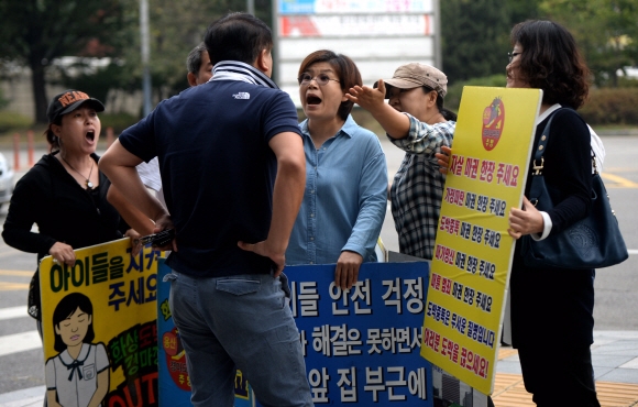 지난 25일 서울 용산구 화상경마장 앞에서 집회 중인 주민들과 경마장에 들어가려던 이용객 사이에 언쟁이 벌어지고 있다. 박지환 기자 popocar@seoul.co.kr