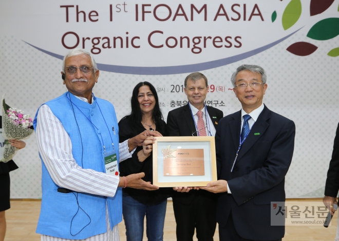 29일 개막한 ‘2016 괴산 아시아유기농대회’에서 아시아 유기농 지도자상을 받은 일본 유기농의 대부·대모인 도모코와 요시노리 가네코 부부와 인도 생명역동농업협회 사르다브만 파텔로 회장이 상을 받은 뒤 기념촬영하고 있다. 괴산군 제공 