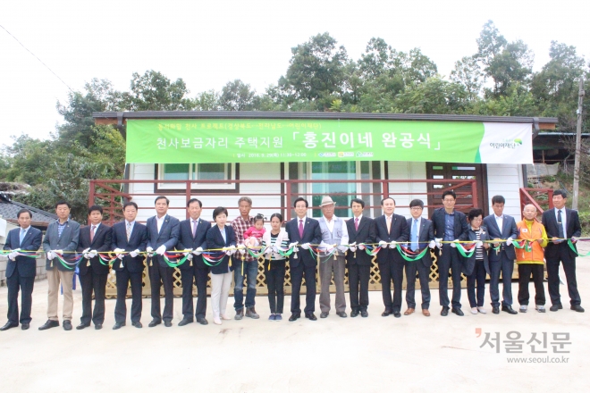 29일 경북 문경시 산북면에서 열린 천사 보금자리 1호 주택 완공식에서 이원경(왼쪽 일곱 번째부터) 경북도 여성정책관, 노홍진씨 부부, 고윤환 문경시장 등이 테이프 커팅을 하고 있다. 경북도 제공. 
