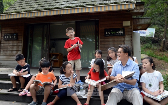 유종필(오른쪽 두 번째) 관악구청장이 관악산 등산로 곁에 통나무집으로 만든 숲속도서관에서 아이들에게 책을 읽어주고 있다. 강성남 선임기자 snk@seoul.co.kr