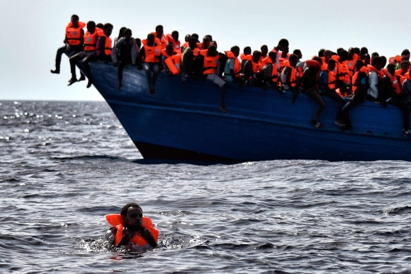 3일(현지시간) 리비아 연안 지중해에서 난민들이 탄 배가 표류하며 구조를 기다리고 있다. AFP 연합뉴스
