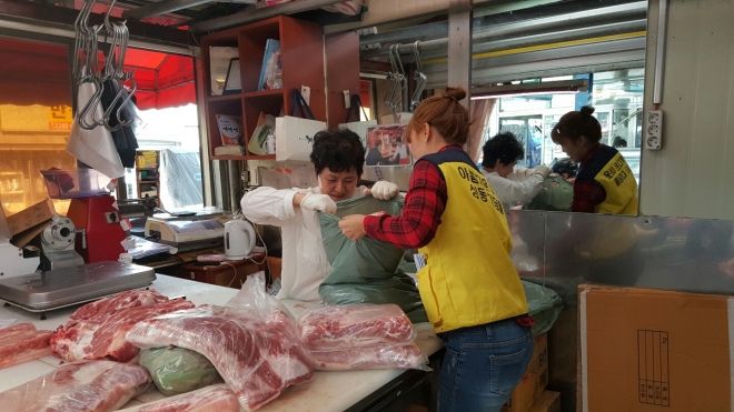 서울 성동구 마장동축산물시장의 한 상인이 어려운 지역 주민에게 나눠줄 고기 등 육류를 복지사에게 전달하고 있다.성동구 제공 