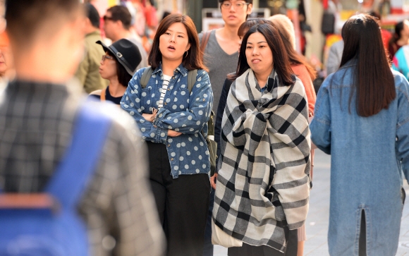 이른 가을 추위가 찾아온 9일 서울 중구 명동에서 시민과 외국인 관광객들이 목도리와 숄등을 걸치고 길을 걷고 있다.  박윤슬 기자 seul@seoul.co.kr