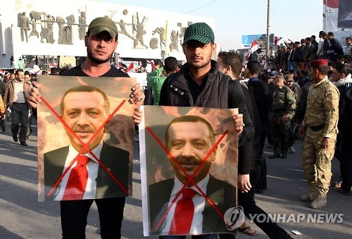 작년 12월 이라크 시아파 민병대 바드르여단 대원들이 엑스자가 그려진 레제프 타이이프 에르도안 터키대통령의 사진을 들고 터키군의 철수를 요구하는 시위를 하고 있다. [EPA=연합뉴스]