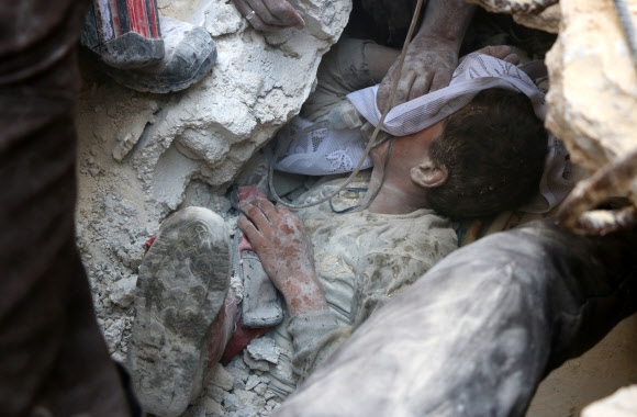 11일(현지시간) 러시아의 대대적 공습이 있었던 시리아 알레포 동부 반군지역의 건물 잔해에서 구출된 어린이가 산소 공급을 받고 있다. 이날 러시아군과 시리아군의 무차별 폭격으로 어린이 4명을 포함, 민간인 16명이 사망했다고 시리아인권관측소가 전했다. AFP 연합뉴스