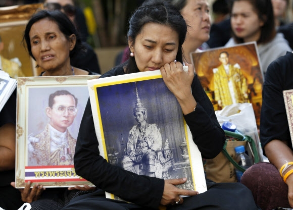 푸미폰 태국 국왕의 서거 소식이 전해지면서 14일(현지시간) 태국 방콕의 씨리랏 국립병원 앞에 모인 국민들이 국왕의 사진을 품에 안고 슬퍼하고 있다. EPA 연합뉴스