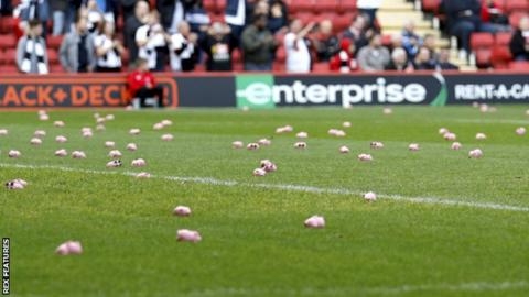 아주 작은 돼지 장난감 수백개가 잉글랜드 리그 원 경기 킥오프를 앞두고 그라운드에 떨어져 있다.  렉스 피처스 캡처 