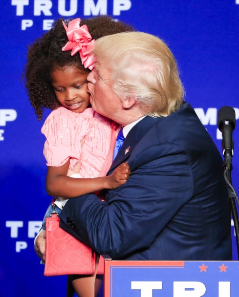 미국 공화당 대선 후보 도널드 트럼프가 17일(현지시간) 미국 위스콘신주 그린베이의 KI 컨벤션 센터에서 개최된 유세 현장에서 흑인 꼬마 아이를 품에 안고 볼에 뽀뽀하고 있다. EPA 연합뉴스