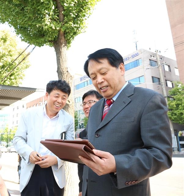 이성 서울 구로구청장이 18일 구로구청 사거리에 있는 한 버스정류장에서 무료 와이파이 서비스에 접속하고 있다. 구로구 제공