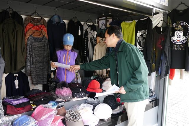 서울 노원구 한 공무원이 지난달 지역 노점상을 대상으로 현장 실태 조사를 벌이고 있다.