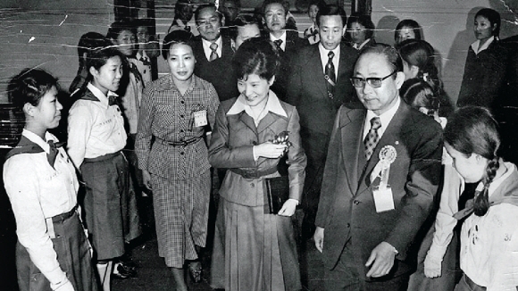 1977년 3월 당시 퍼스트레이디 자리를 대신하던 박근혜(왼쪽 네 번째) 대통령이 새마을궐기대회에 참석해 최태민씨의 안내를 받으며 걸스카우트 대원들에게 인사하고 있다.