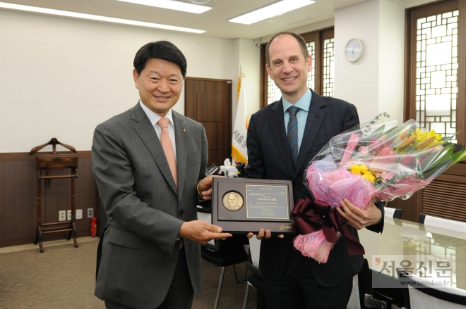 에릭 월시(오른쪽) 주한 캐나다 대사가 27일 서울 중구청장실에서 명예구민증을 품에 안고서 최창식 중구청장과 함께 함박웃음을 짓고 있다. 서울 중구 제공