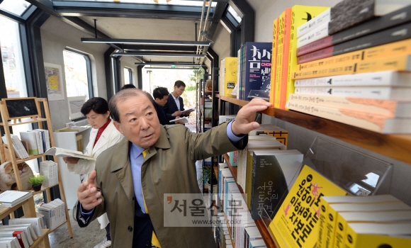 박홍섭 서울 마포구청장이 27일 홍대입구역 6번 출구 앞에 조성한 ‘경의선 책거리’에 있는 열차 모양의 부스 안에서 책을 고르고 있다. 박윤슬 기자 seul@seoul.co.kr