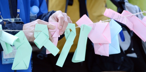시민들이 둘레길 내 마련된 ‘소원쪽지 달기’ 이벤트에서 자신들이 적은 편지를 줄에 매달고 있다.  박윤슬 기자 seul@seoul.co.kr