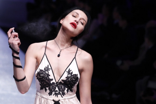 모델이 30일(현지시간) 중국 베이징에서 열린 ‘메르세데스-벤츠 차이나 패션 위크(the Mercedes-Benz China Fashion Week )’ 중 ‘Aimer 란제리 콜렉션’의 작품을 선보이며 향수를 뿌리고 있다. AP 연합뉴스