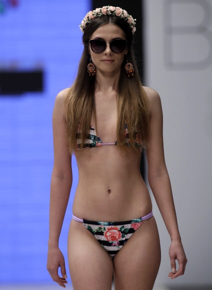 4일(현지시간) 벨라루스 민스크에서 열린 ‘벨라루스 패션위크’에서 수영복 브랜드 ‘Totti’의 비키니를 입은 모델이 런웨이를 걷고 있다.<br>AP 연합뉴스