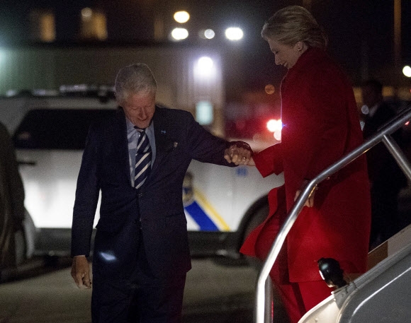 미국 민주당 대통령 후보 힐러리 클린턴이 7일(현지시간) 미국 필라델피아 국제 공항에 도착해 전 미국 대통령인 빌 클린턴의 손을 잡고 계단을 내려오고 있다. AP 연합뉴스